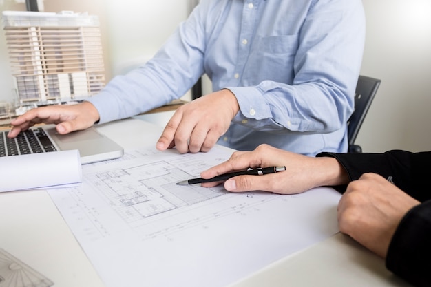 Plan de dibujo de mano de ingeniero de la persona en impresión azul con equipo de arquitecto