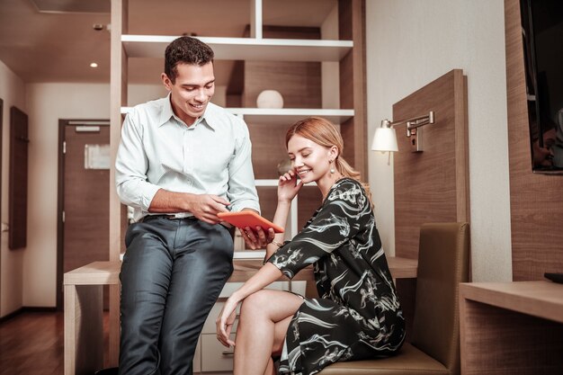 Plan de negocios. Marido mostrando su plan de negocios creativo a su atractiva esposa con un vestido elegante