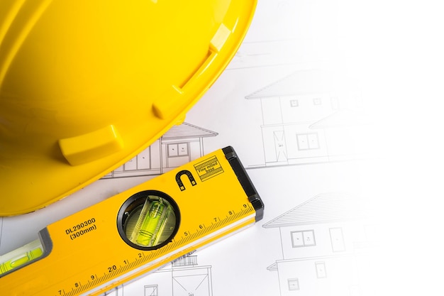 Plan de proyecto de casa arquitectónica con casco amarillo y herramientas de construcción de ingeniería