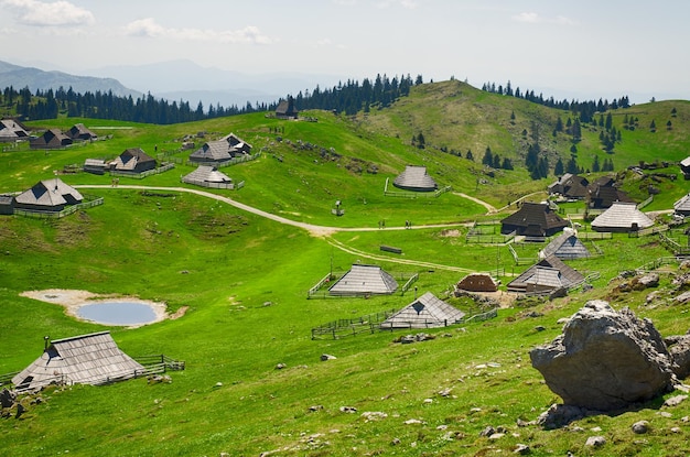 Planalto de pasto grande. alpes, eslovênia. cabana de montanha ou casa na colina verde. paisagem alpina