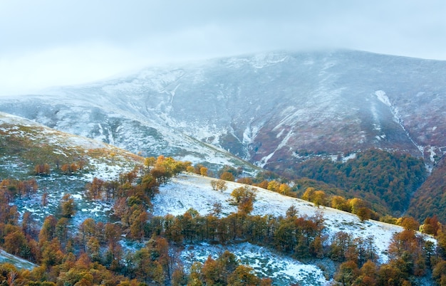 Planalto montanhoso dos cárpatos de outubro com neve do inverno e folhagem colorida de outono