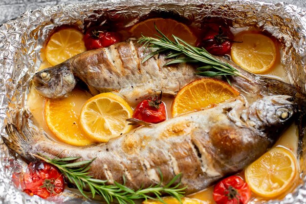 Una plancha de pescado con verduras y romero por encima.