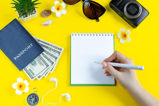 Planejamento de viagens de verão, câmera de óculos de sol para passaporte e dinheiro em um fundo amarelo