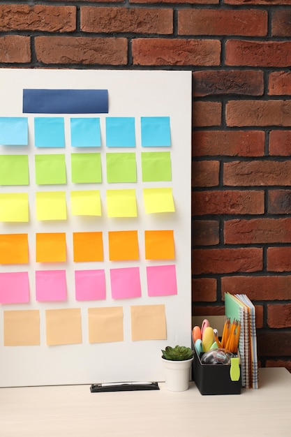 Planejamento e otimização de processos de negócio Lugar de trabalho com notas de papel coloridas e outros artigos de papelaria na mesa