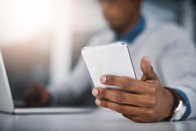 Planejando seu dia da maneira inteligente Captura de um empresário irreconhecível usando um celular em um escritório