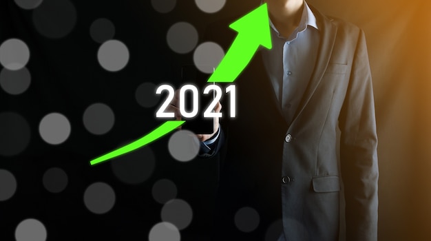 Planen Sie ein positives Geschäftswachstum im Konzept des Jahres 2021. Geschäftsmann planen und erhöhen positive Indikatoren in seinem Geschäft, Aufwachsen von Geschäftskonzepten.
