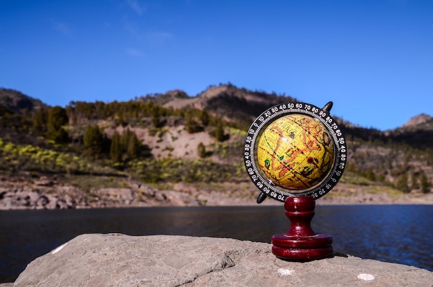 Planet Globe Earth auf dem Felsen in der Nähe des Wassers