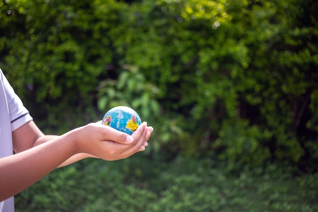 Foto el planeta tierra en las manos del niño salva y protege al mundo concepto ambiental en el día de la tierra