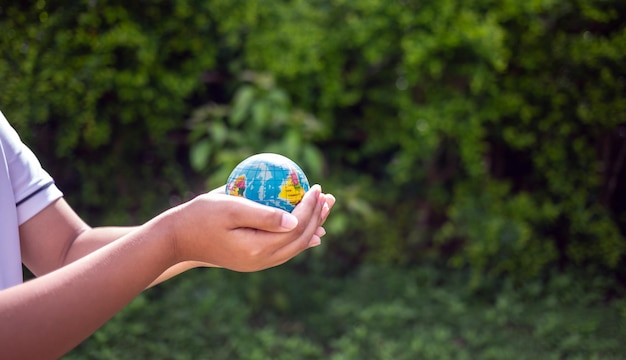 Foto el planeta tierra en las manos del niño salva y protege el medio ambiente del mundo