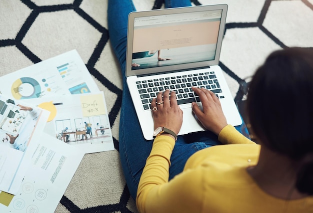 Planificación de documentos y mujer en el análisis de datos de la pantalla de la computadora o diseño de sitios web para el trabajo remoto en la investigación comercial Gráficos de gráficos y edición de escritura de personas e infografías en una computadora portátil en el piso