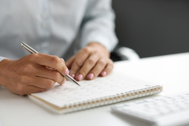 Planificación empresarial y empresaria trabajando y revisando el calendario en el lugar de trabajo tomando notas en