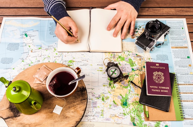 Planificación de viajes. Hombre escribiendo en notas de bloque