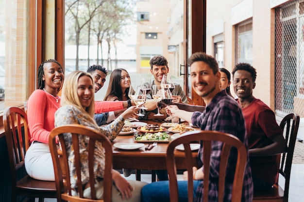 Plano completo de un grupo de amigos celebrando una comida en un restaurante