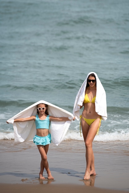 Foto plano completo madre y niña con toallas.