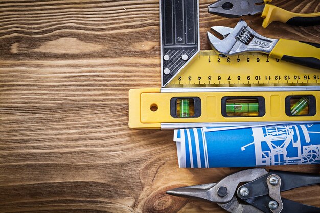 Foto plano de construcción nivel regla cuadrada alicates tijeras de estaño llave ajustable en tablero de madera