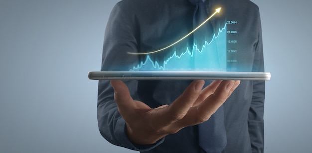 Plano de empresário gráfico de crescimento e aumento de indicadores positivos de gráfico em seu negócio, tablet na mão