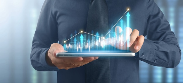 Plano de empresário gráfico de crescimento e aumento de indicadores positivos de gráfico em seu negócio, tablet na mão