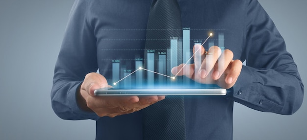 Plano de empresário gráfico de crescimento e aumento de indicadores positivos de gráfico em seu negócio, tablet na mão