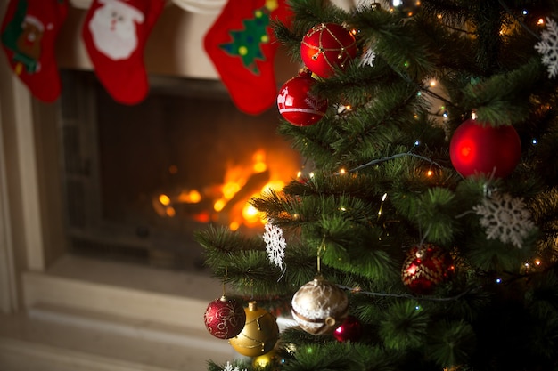 Foto plano de fundo da árvore de natal na sala de estar com lareira decorada com meias tradicionais para presentes