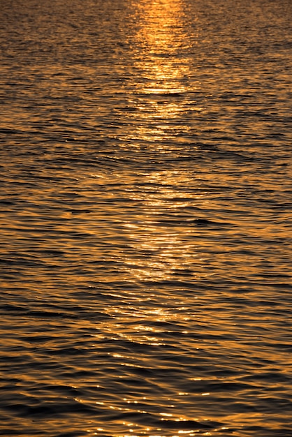 Plano de fundo da superfície da água na hora do sol. Tiro vertical