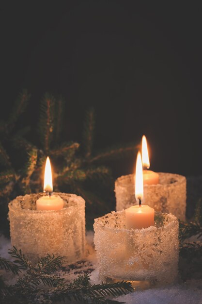 Plano de fundo de ano novo. Natal acendendo velas com pinheiro na neve