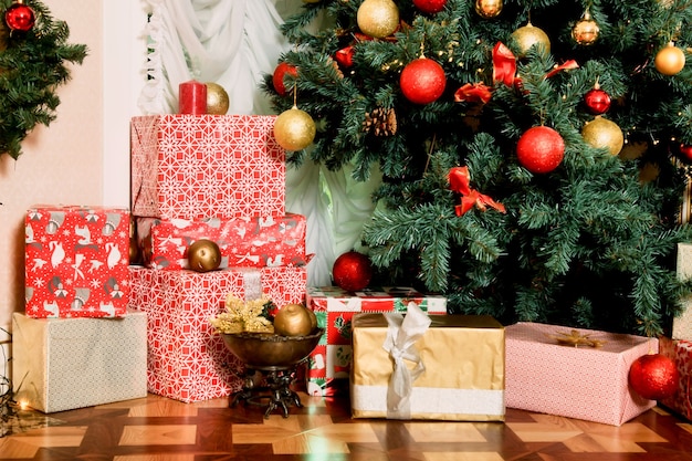 Plano de fundo de férias de Natal de close-up de árvore decorada com presentes e bolas de Natal e brinquedos. Conceito de comemorar o feliz ano novo. Decoração ou no interior da casa. Copie o espaço para o site