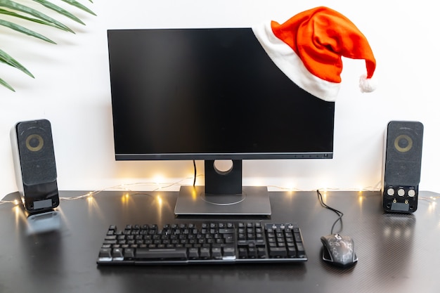 Plano de fundo de natal com configuração de computador com um chapéu e espaço de cópia para o texto