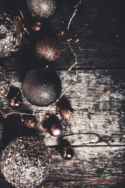 Plano de fundo de natal ou ano novo. bolas de decoração de brinquedo de árvore de natal vintage e guirlanda de luz sobre fundo de madeira rústico, foco seletivo, espaço de cópia