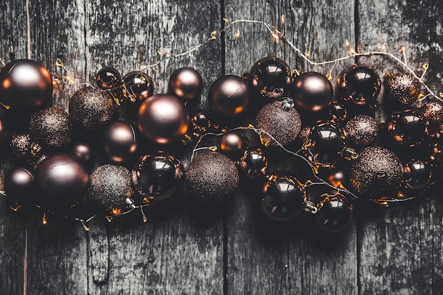 Plano de fundo de Natal ou ano novo. Bolas de decoração de brinquedo de árvore de Natal vintage e guirlanda de luz sobre fundo de madeira rústico, foco seletivo, espaço de cópia