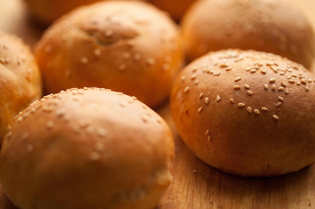 Plano de fundo de pães caseiros com sementes de gergelim para hambúrgueres. pão feito em casa. produto natural. estilo de vida