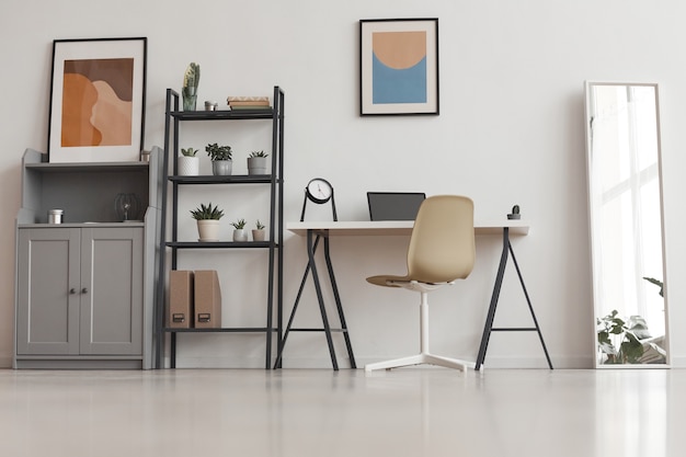 Plano de fundo de uma mesa mínima de escritório em casa em um apartamento moderno decorado com plantas e arte abstrata, copie o espaço