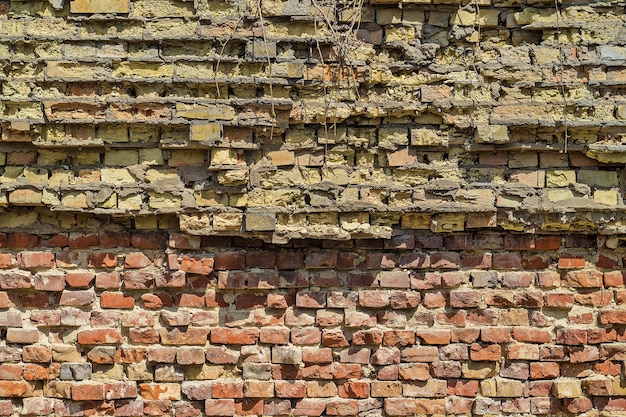 Plano de fundo de uma velha parede quebrada de tijolos vermelhos e amarelos