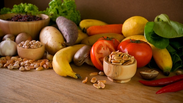 Foto plano de fundo de vários vegetais saudáveis na mesa de madeira, frutas, legumes, sementes e nozes