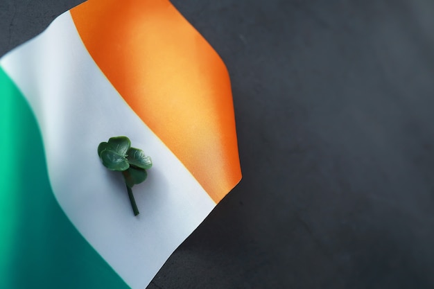Plano de fundo dia de são patrício com bandeira da irlanda. feriado religioso cristão. símbolo do trevo de quatro folhas de boa sorte.