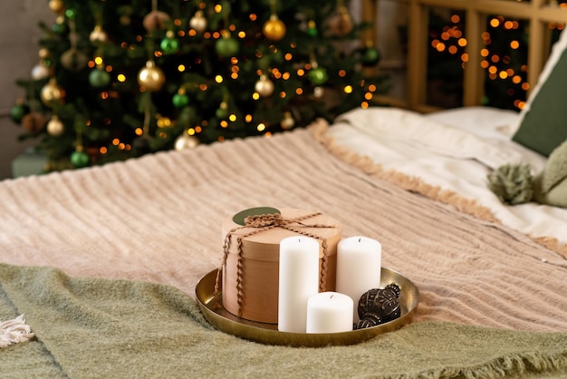 Plano de fundo Natal e ano novo - caixas de presente e velas, no contexto das luzes de bokeh de uma árvore de Natal decorada. Foco seletivo suave.