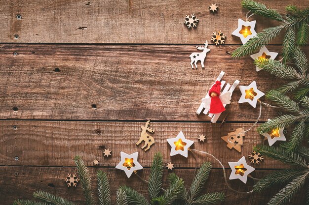 Plano de fundo Natal ou ano novo com galhos de pinheiro, guirlanda, bolas de Natal, caixa de presente, flocos de neve de madeira e estrelas no fundo escuro de madeira. Lugar para o seu texto