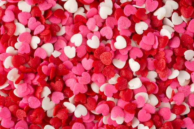 Plano de fundo romântico, vista superior de um grupo de doces em forma de coração vermelho, branco e rosa