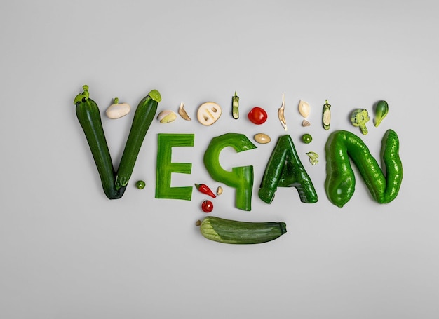 plano em forma de coração e sacola de compras e compras curto fundo vegano e logotipo vegano arranjo vegetal letras veganas feitas de vegetais em fundo branco