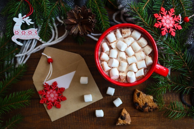 Plano festivo de Navidad con sobre de galletas de malvaviscos de chocolate caliente y árbol de Navidad