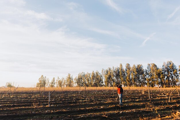 Plano general de un granjero latino caminando en medio de las tierras de cultivo