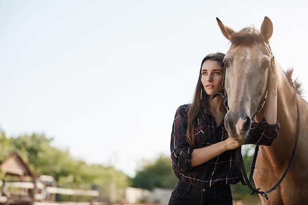 Plano general de una joven y hermosa subgerente de granja caminando a caballo a los establos