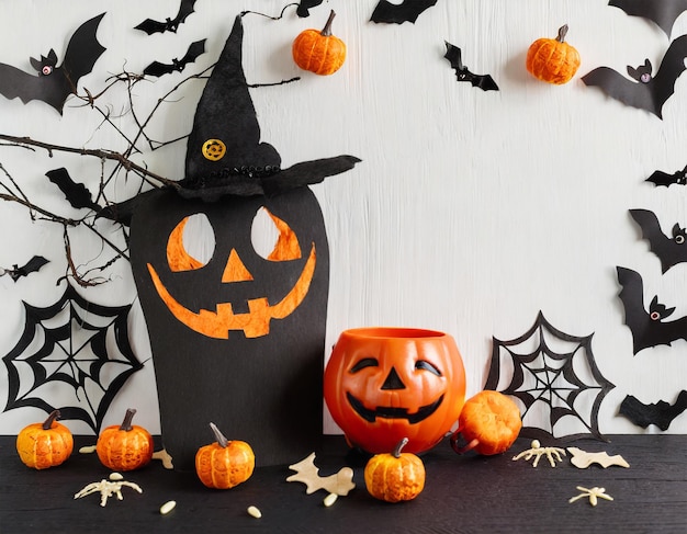 Plano de Halloween con máscara de calabaza, sombrero de bruja, murciélagos voladores, tela decorativa y fantasma espeluznante en