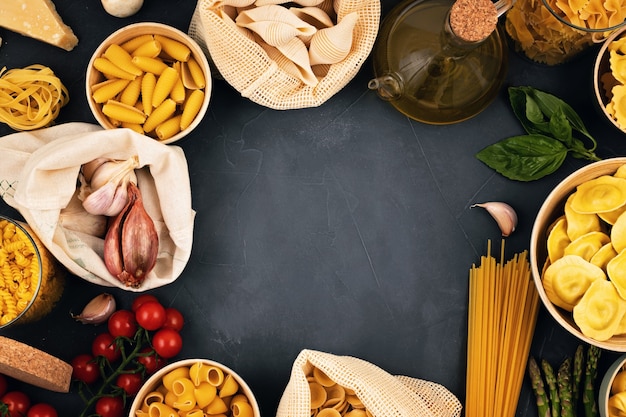 Plano horizontal com massa italiana orgânica tradicional e ingredientes de cozinha em sacos de algodão reutilizáveis e recipientes de vidro. Zero desperdício, conceito livre de plástico