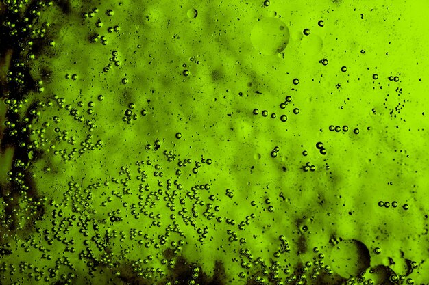 Plano macro de emulsión de aceite de agua sobre fondo de color