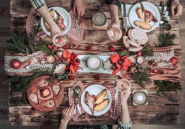 Plano de manos de amigos comiendo y bebiendo juntos. Vista superior de personas que tienen fiesta, reunión, celebrando juntos en la mesa rústica de madera