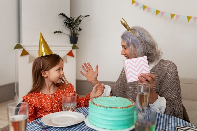 Foto plano medio anciana y niña celebrando cumpleaños