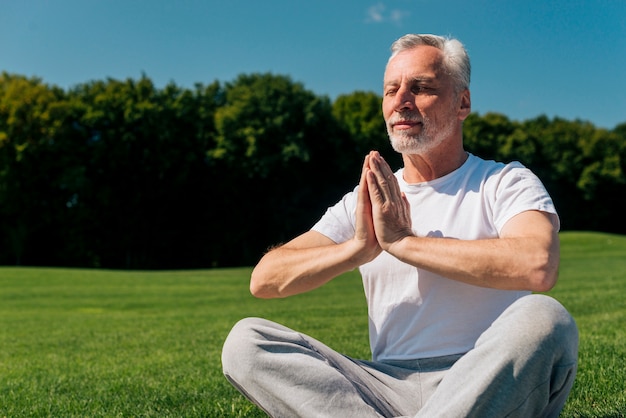 Plano medio anciano meditando en la naturaleza