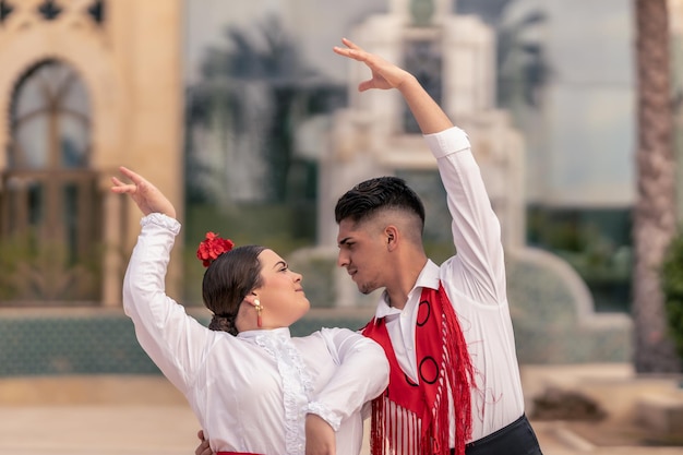 Plano médio de um jovem dançarino de flamenco abraçando seu parceiro enquanto dançam