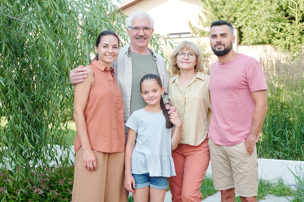 Plano médio de uma família de cinco pessoas juntas em um parque moderno em um dia de verão