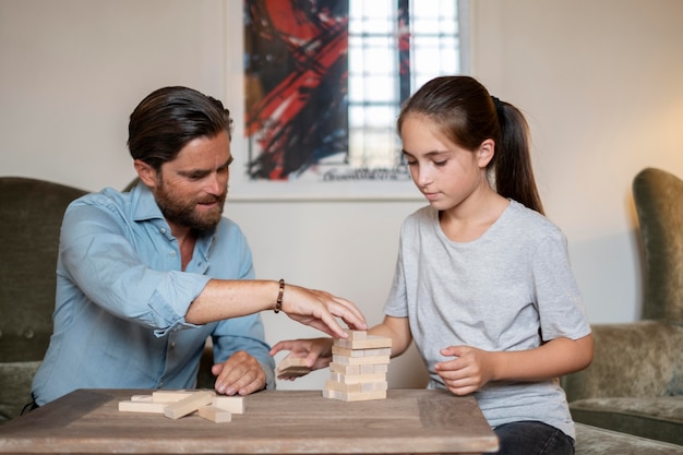 Foto plano medio, hombre e hija, juego